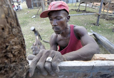 Un Haïtien construit un abris temporaire pour sa famille en utilisant des matériaux de  bâtiments effondrés, mercredi 20 janvier 2010